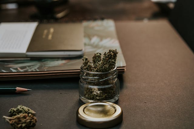 a small glass jar of dried marijuana leaves